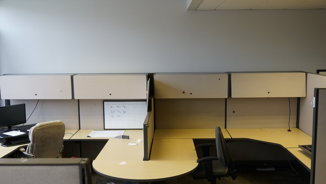 Two desk spaces next to each other, they both have their own chairs and 2 cabinets each.