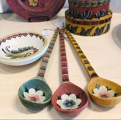 Bowls, spoons, plates, and boxes all decorated in a Scandinavian style with bright colors and bold lines.